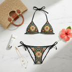 A perfectly curated flat lay on a polished white marble surface. The tie-side bikini is neatly folded next to a bottle of high-end sunscreen (e.g., La Mer), a woven designer beach bag, delicate gold layered necklaces, and a fresh tropical hibiscus flower. The lighting is soft, natural daylight. The aesthetic is clean, luxurious, and aspirational Instagram content.