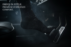 A close-up, high-contrast cinematic shot of the sock on a foot, stepping onto the chrome clutch pedal of a classic muscle car. Smoke billows slightly around the foot. The lighting is moody and intense, highlighting the detailed weave of the car design on the sock and the metallic sheen of the pedal. Text overlay in elegant font: 'DRIVE IN STYLE. PREMIUM CUSHIONED COMFORT.'