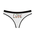Ethereal shot, a white thong with colorful heart mosaic 'LOVE' text hanging on a thin black silk hanger, in front of a blowing sheer white curtain, soft focus, dreamy cinematic lighting.