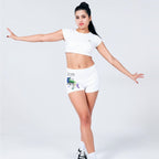 Ethereal morning scene in a misty pine forest, a woman performing a graceful dance move, wearing white graphic shorts, soft sunlight filtering through trees, dreamy and mysterious vibe, photorealistic.