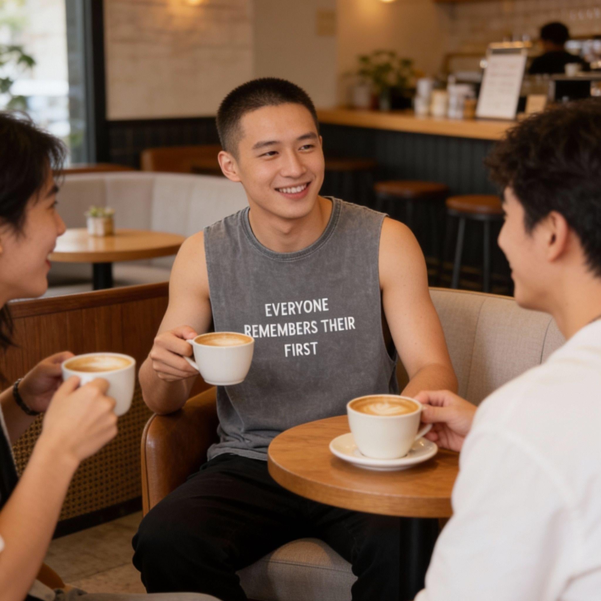 Close up of the 'EVERYONE REMEMBERS THEIR FIRST' text on a mineral wash fabric, golden hour lighting, cinematic grain, emotional and mysterious atmosphere.